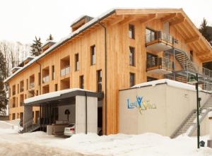 a building with a lot of snow in front of it at LoriVita Residenz Saalbach in Saalbach Hinterglemm