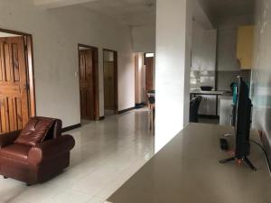 een woonkamer met een bank en een televisie in een kamer bij GH Apartelles in Baguio