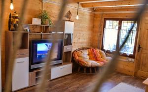 a living room with a television and a chair at Chalet Mediterraneo in Ulcinj