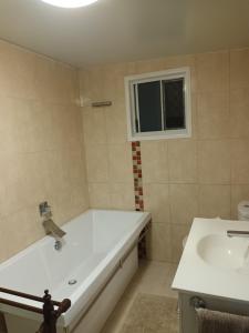 łazienka z wanną i umywalką w obiekcie Tropical Poolside Retreat w mieście Nelly Bay