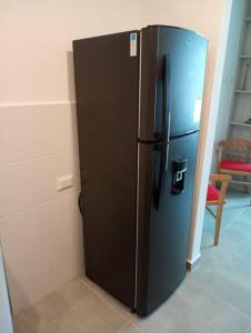 a black refrigerator in a room with a wall at Apartasuite moderno y elegante en Playa Salguero in Gaira