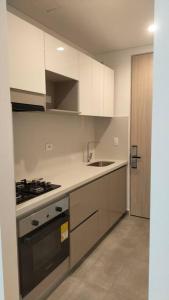 a kitchen with white cabinets and a stove top oven at Apartasuite moderno y elegante en Playa Salguero in Gaira