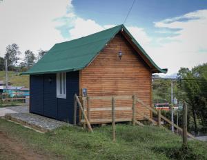una pequeña casa de madera con techo verde en Chalet Santa Clara, en Jericó