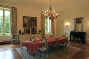 a dining room with a table and chairs and a chandelier at Château de la Marronnière in Aizenay