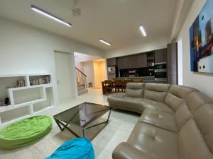 a living room with a couch and a glass table at BY THE SEA - Penthouse 3 bedroom in Batu Ferringhi