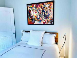 1 dormitorio con 1 cama con una pintura en la pared en Garfield Historic Chateau in Downtown Phoenix en Phoenix