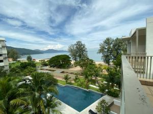 a view of the pool from the balcony of a resort at BY THE SEA - Penthouse 3 bedroom in Batu Ferringhi