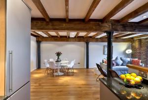 een keuken en een woonkamer met een tafel en een bank bij Wild Roses Serviced Apartments - ExCel Warehouse 1 in Londen