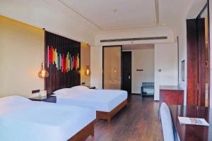A bed or beds in a room at Mangrove Tree Resort World Sanya Bay-Coconut
