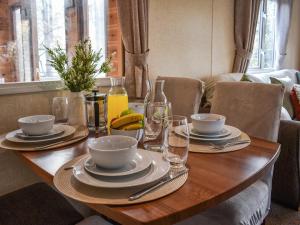 une table en bois avec des assiettes et des bols de nourriture dans l'établissement Robins Retreat, à Weybourne