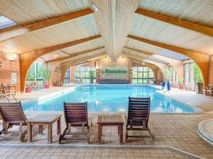 a large swimming pool with chairs and a table at Robins Retreat in Weybourne