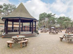 - un pavillon avec des tables de pique-nique et des bancs dans un parc dans l'établissement Robins Retreat, à Weybourne