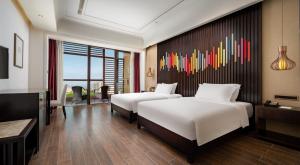 A bed or beds in a room at Mangrove Tree Resort World Sanya Bay-Coconut