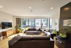 een woonkamer met een bank en een tv bij Cosy Luxury City Fringe in Auckland