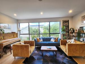 sala de estar con sofá azul y piano en Cosy Luxury City Fringe en Auckland