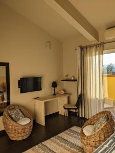 a living room with two chairs and a television at Le Mas Del Cavalier in Baho