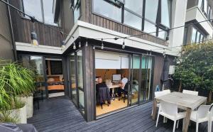 een patio met een tafel en stoelen bij Cosy Luxury City Fringe in Auckland