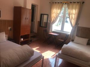 a hotel room with two beds and a window at iDorm B&B - idorm Mỹ in Da Lat