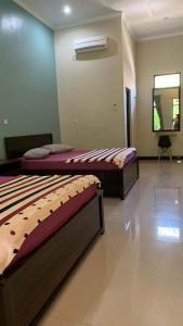 um quarto com duas camas num quarto com um espelho em Sederhana Homestay em Batukaras