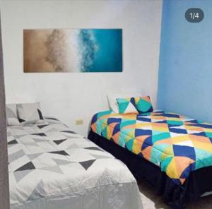1 dormitorio con 1 cama y una pintura en la pared en Casa de Alexis en Puerto Baquerizo Moreno