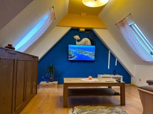sala de estar con mesa y TV en una pared azul en Piano Apartment Halle Center - Netflix- Free WiFi 3, en Halle an der Saale