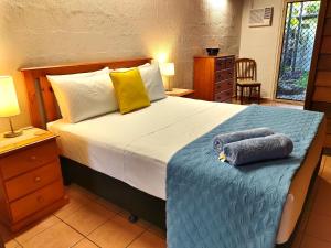1 dormitorio con 1 cama con 2 toallas en Beachside Cottage - A Private Peaceful Hidden Gem 50m to Beach, en Nelly Bay