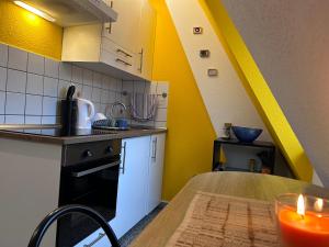 a kitchen with yellow walls and a table with a candle at Piano Apartment Halle Center - Netflix- Free WiFi 3 in Halle an der Saale