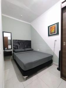 1 dormitorio con 1 cama en una habitación blanca en Apartamento turístico Medellín Laureles, By Family Rooms, en Medellín