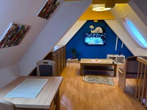 a attic room with a table and a blue wall at Piano Apartment Halle Center - Netflix- Free WiFi 3 in Halle an der Saale