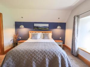 トラウトベックにあるBoxwood Cottageの青い壁のベッドルーム1室(大型ベッド1台付)