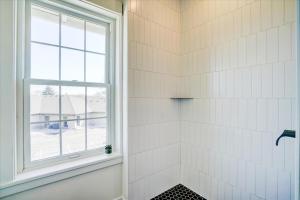 a bathroom with a shower with a window at 202 - Single Queen in Waunakee +19 photos