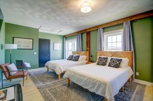 two beds in a room with green walls at 203 - Double Queen in Waunakee
