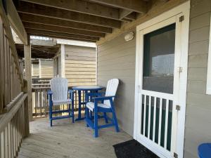 two chairs and a table on the porch of a house at NC 12 56821-7 Condo in Hatteras
