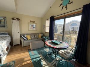 a living room with a bed a couch and a table at NC 12 56821-7 Condo in Hatteras +8 photos