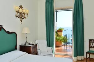 a bedroom with a bed and a view of the ocean at Buca Di Bacco in Positano