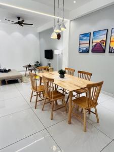 een eetkamer met een houten tafel en stoelen bij Inn Homestay in Teluk Intan