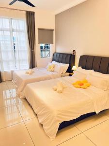 two beds in a hotel room with stuffed animals on them at Inn Homestay in Teluk Intan