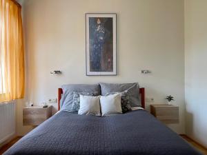 a bedroom with a blue bed with a painting on the wall at Penthouse w Private Rooftop and Free parking in Budapest