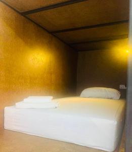 uma cama com duas almofadas num quarto em The Black Sheep Hostel em Haad Rin