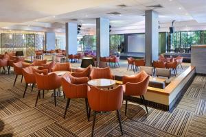 um restaurante com cadeiras laranja e um bar em Lagoona by Isrotel Collection em Eilat