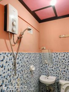 y baño con ducha y lavamanos. en Bogah Lodge, en Banaue