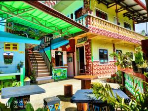 a building with benches and tables in front of it at Bogah Lodge in Banaue