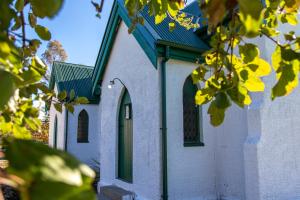 a small white church with a green roof at The Church Millers Flat in Millers Flat