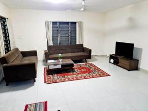 a living room with a couch and a tv at Masters 2 Bedroom Apartment Westfield in Nadi