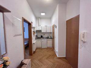 a kitchen with white cabinets and a wooden floor at Piano Apartment in Halle Center - Netflix - Free WiFi 1 in Halle an der Saale