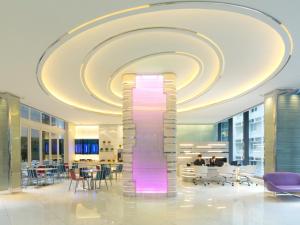 una grande hall con un grande lampadario a braccio e una grande colonna di vetro di iclub Sheung Wan Hotel a Hong Kong