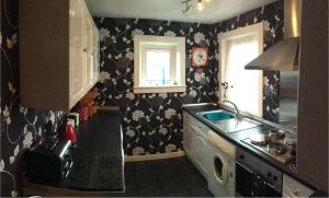 a small kitchen with black and white wallpaper at Westview Accommodation in Stornoway