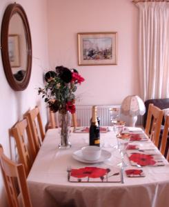 a table with a white table cloth and a bottle of wine at Westview Accommodation in Stornoway