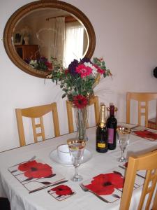 una mesa con un jarrón de flores y un espejo en Westview Accommodation en Stornoway