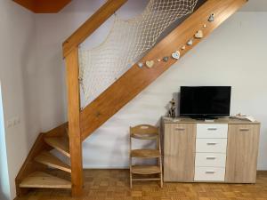 uma escada num quarto com uma secretária e uma televisão em Lotty em Catez ob Savi